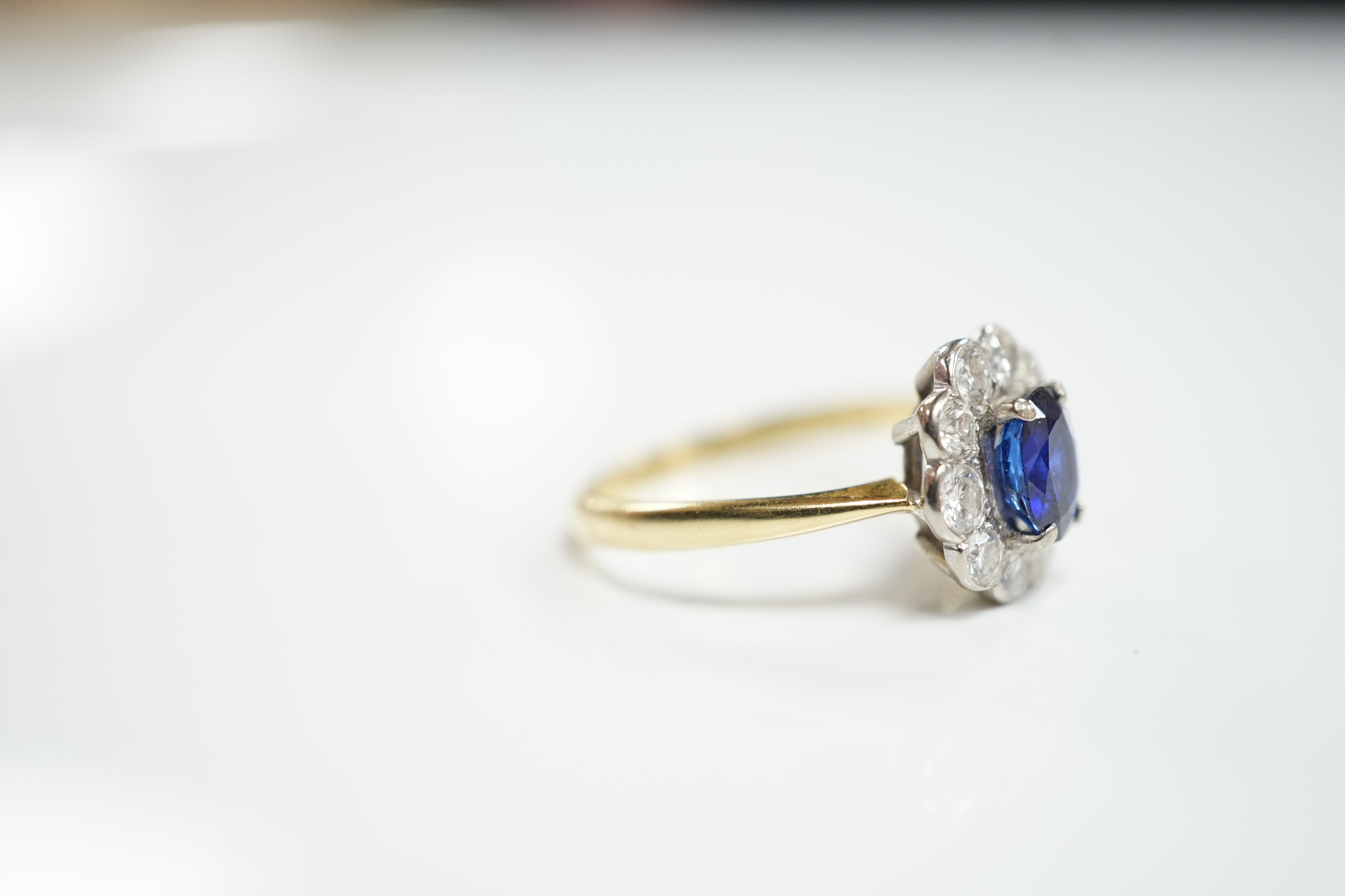 A modern 18ct gold, sapphire and diamond set circular cluster ring, size P/Q, gross weight 3.8 grams.